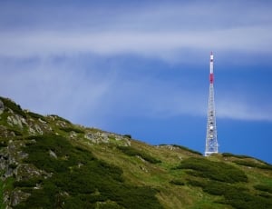 white and red steel tower under blue skies during daytime thumbnail