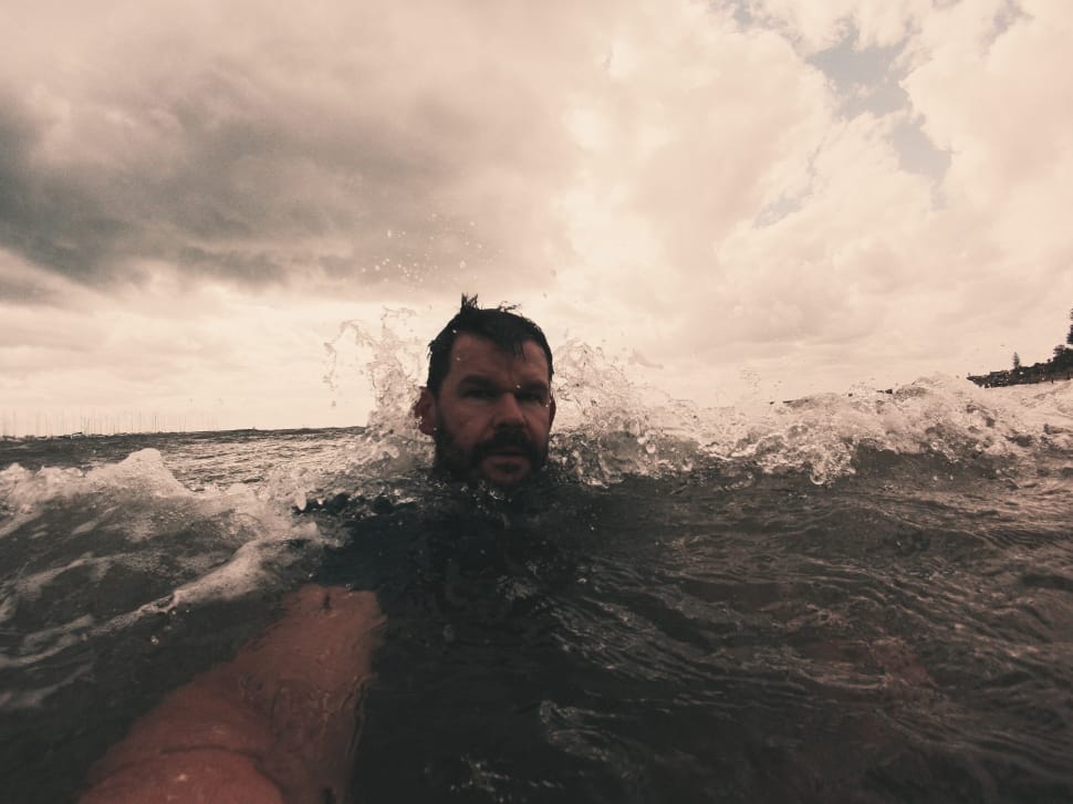 man in body of water taking a selfie preview