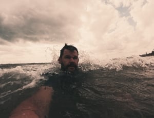 man in body of water taking a selfie thumbnail