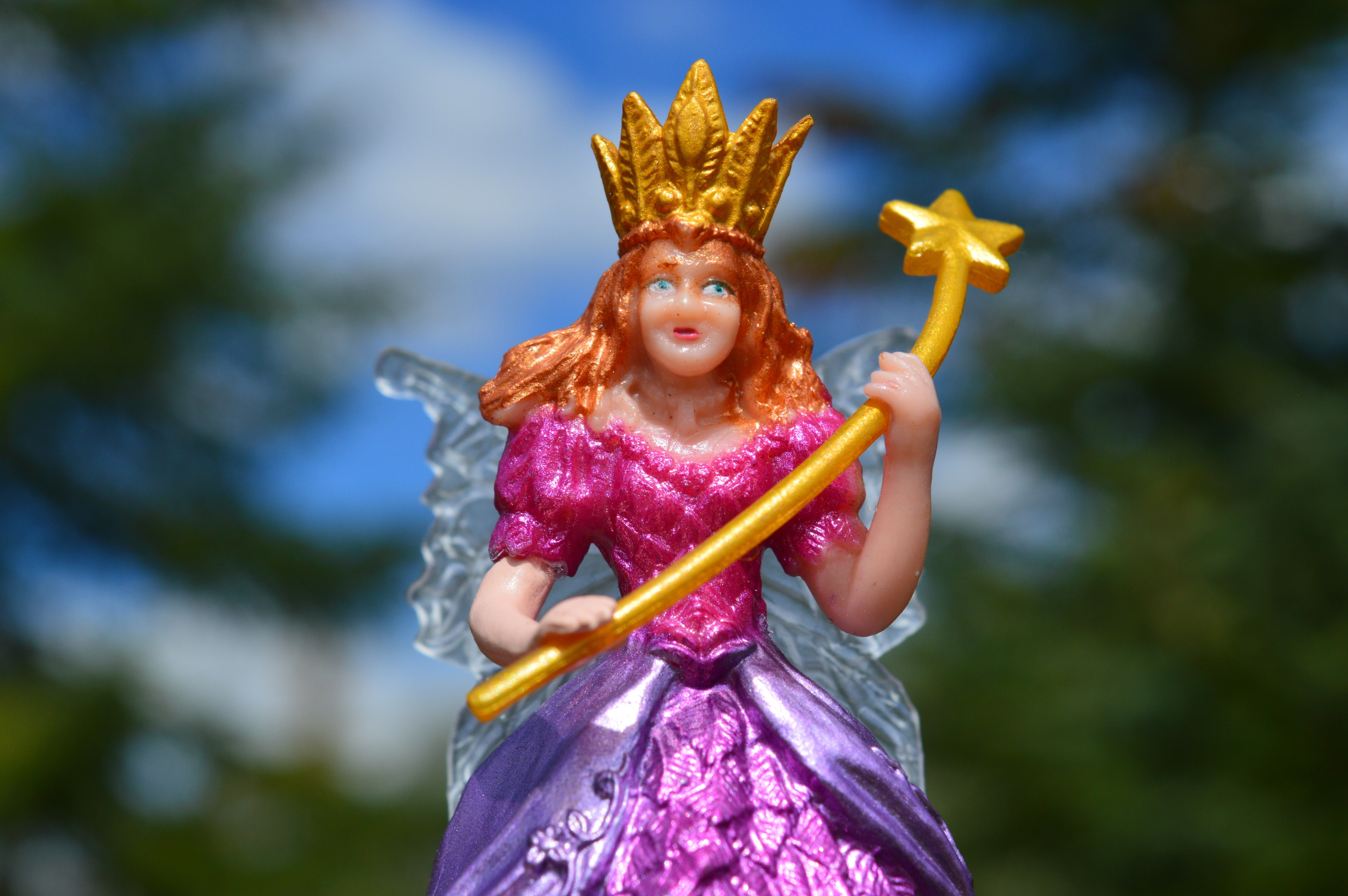 fairy in purple and pink dress holding wand with crown
