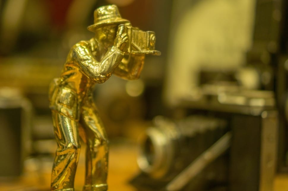 person using vintage camera golf figurine preview