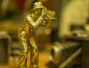 person using vintage camera golf figurine thumbnail