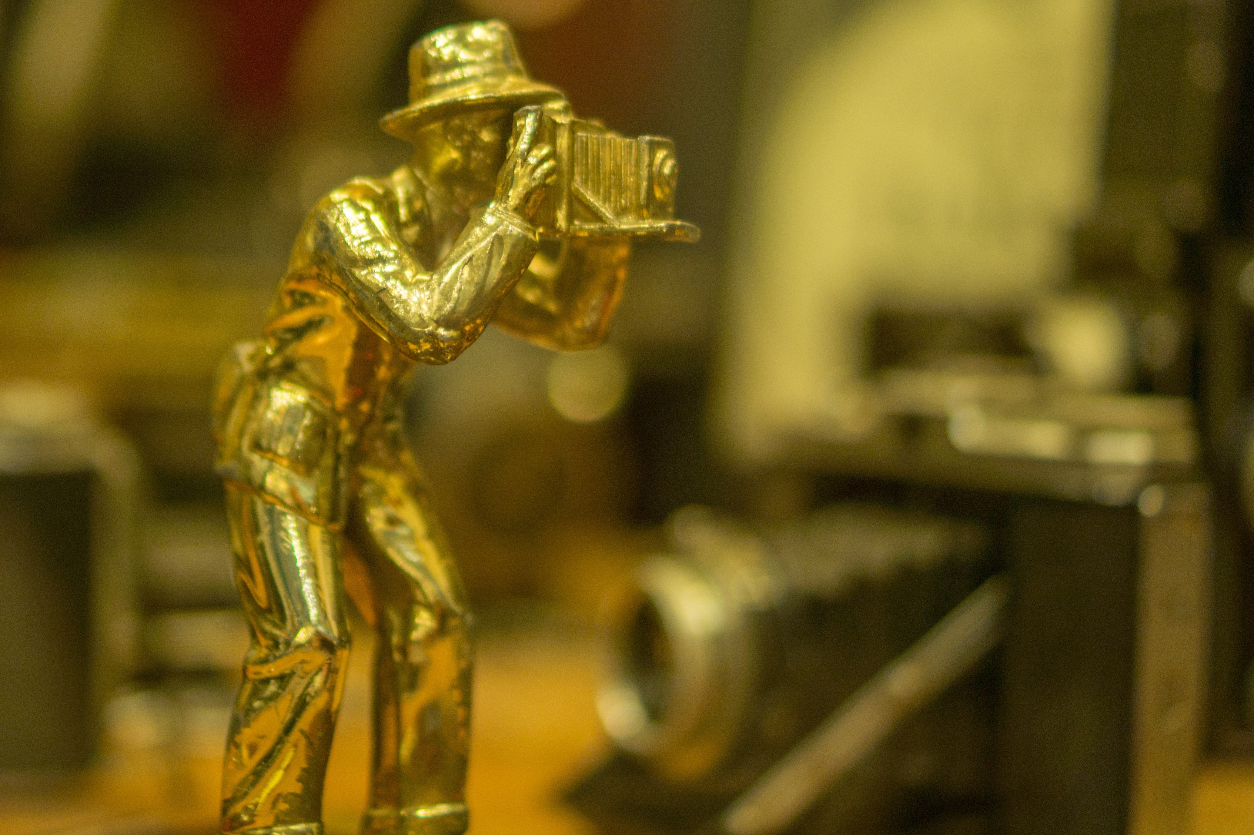 person using vintage camera golf figurine