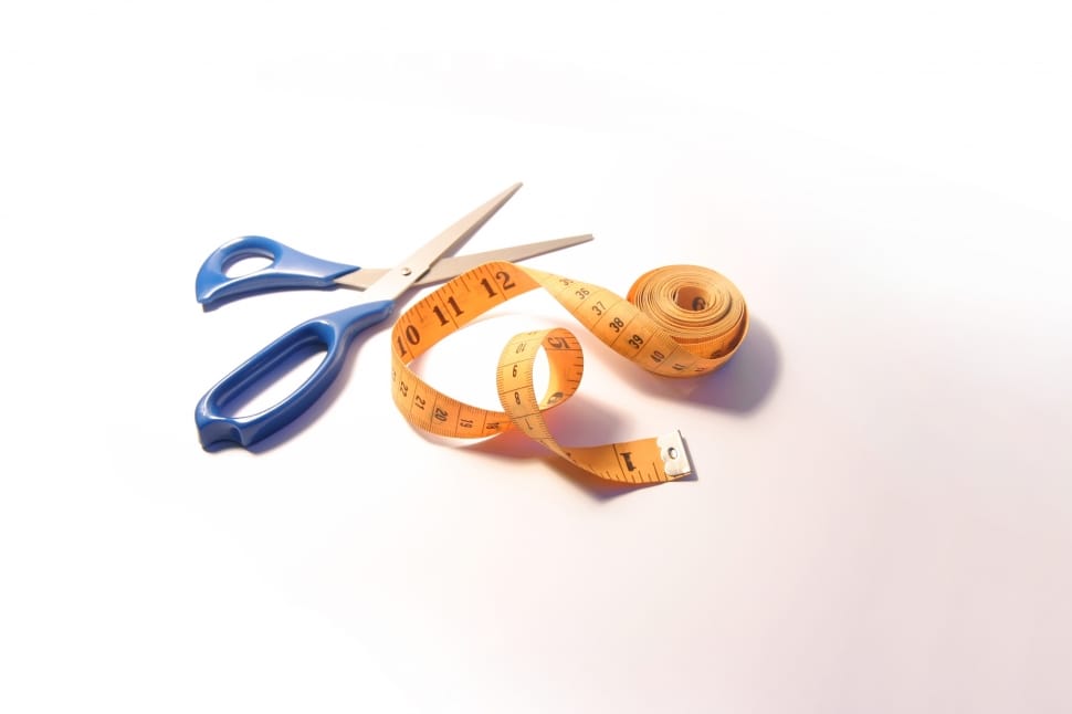 yellow tape measure beside a blue handled scissor preview