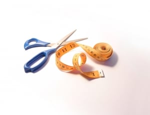 yellow tape measure beside a blue handled scissor thumbnail