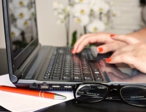 woman in orange manicure typing on black laptop thumbnail