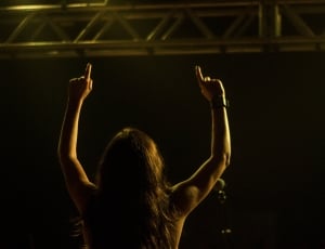 person raising up hand on stage thumbnail