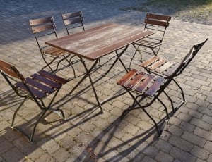 brown wooden table with 6 wooden armless chairs thumbnail