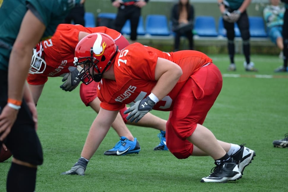 man in red football jersey playing football preview