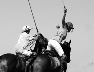 grasycale photo of 2 people riding 2 horses thumbnail