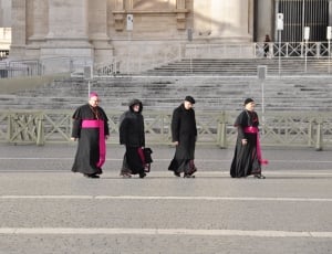 four pope walking on pathway during day time thumbnail