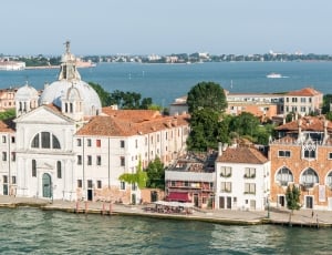 white and beige buildings near body of water photo thumbnail