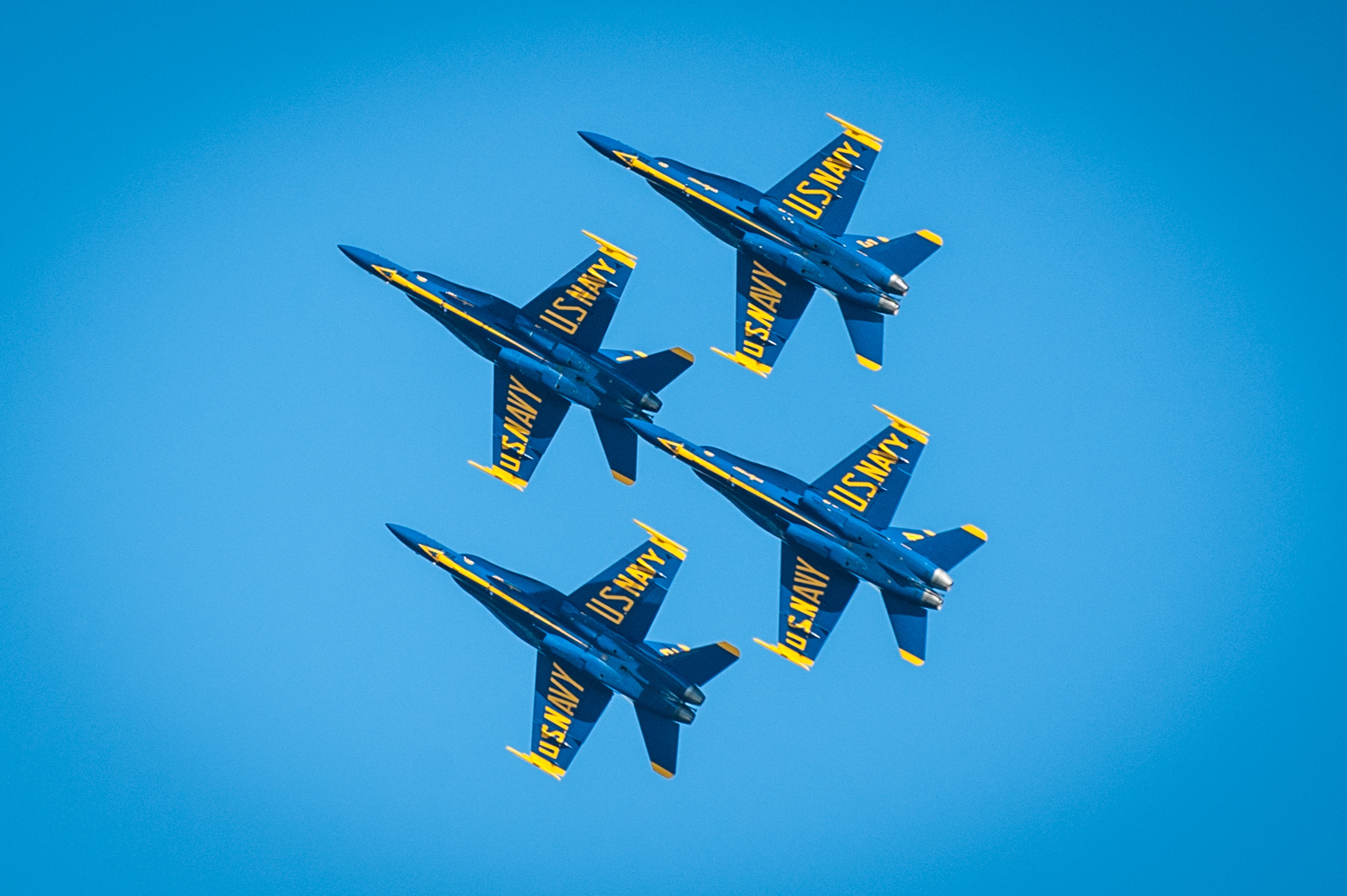 4 blue and yellow u.s. navy jet fighter