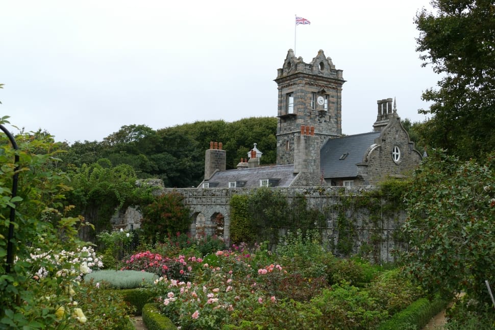 grey concrete castle with flag and flower garden preview
