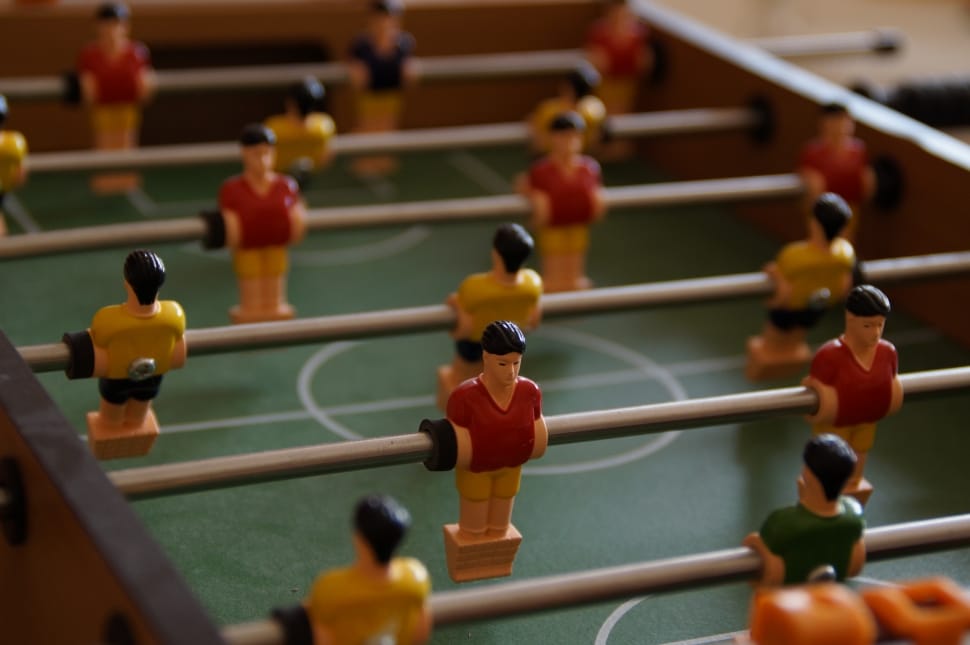 brown and green wooden fooseball table preview