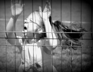 grayscale of girl near fence thumbnail