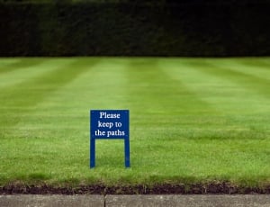 please keep to the paths signboard on grass field thumbnail