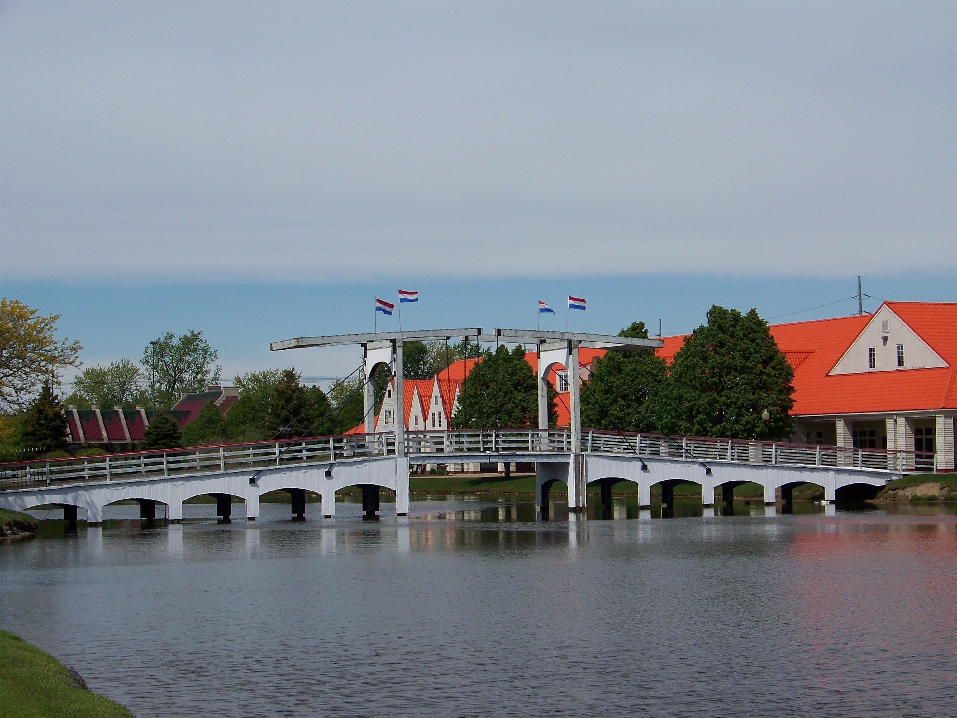 white traditional bridge near orange roofed house