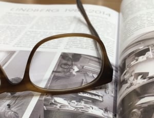 brown framed eyeglasses on top of grayscale photography magazine thumbnail