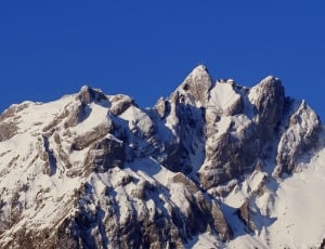 in distant photography of snow covered mountain range thumbnail