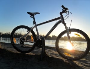 white and black Erida mountain bike beside lake under clear blue sky thumbnail
