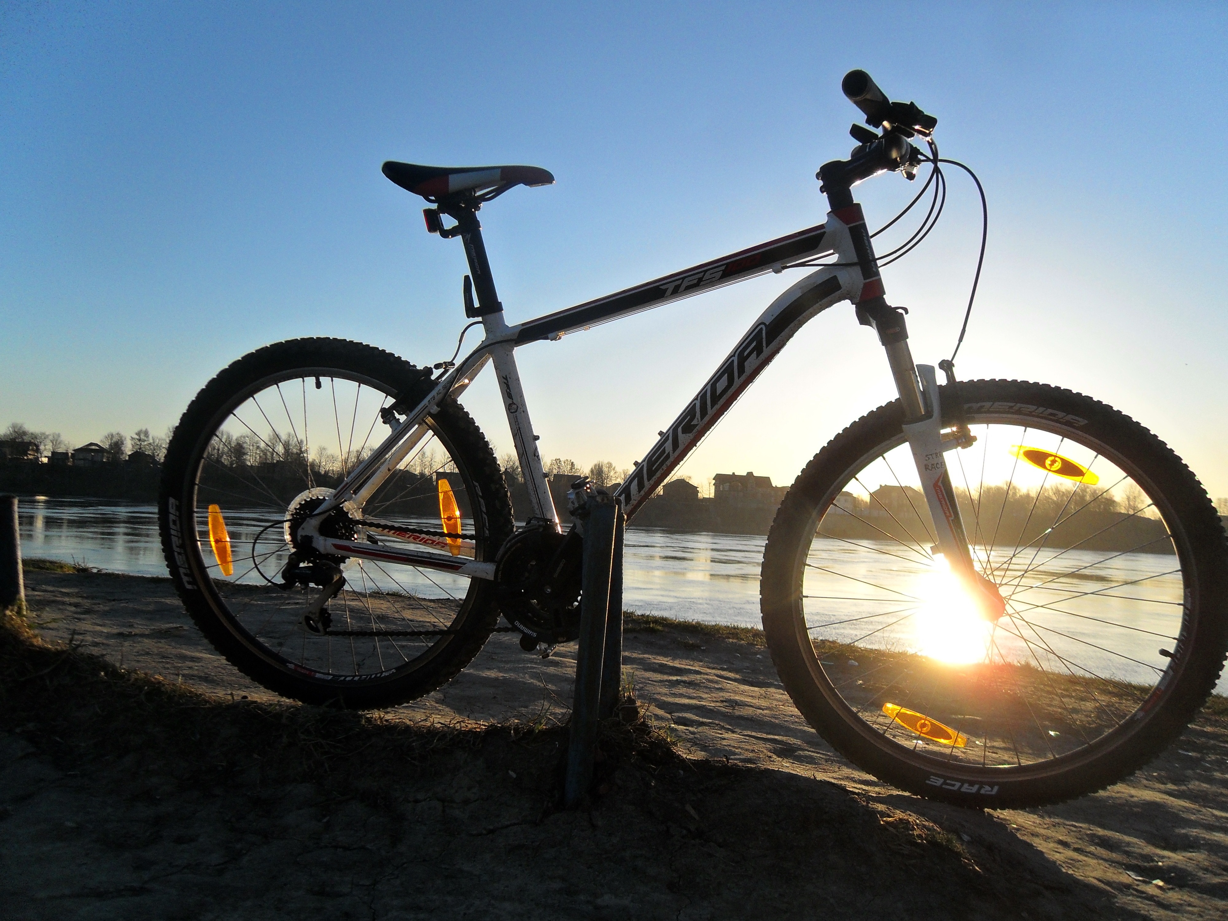 white and black Erida mountain bike beside lake under clear blue sky