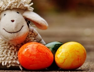 Sheep plush toy beside of green, orange, and yellow eggs thumbnail