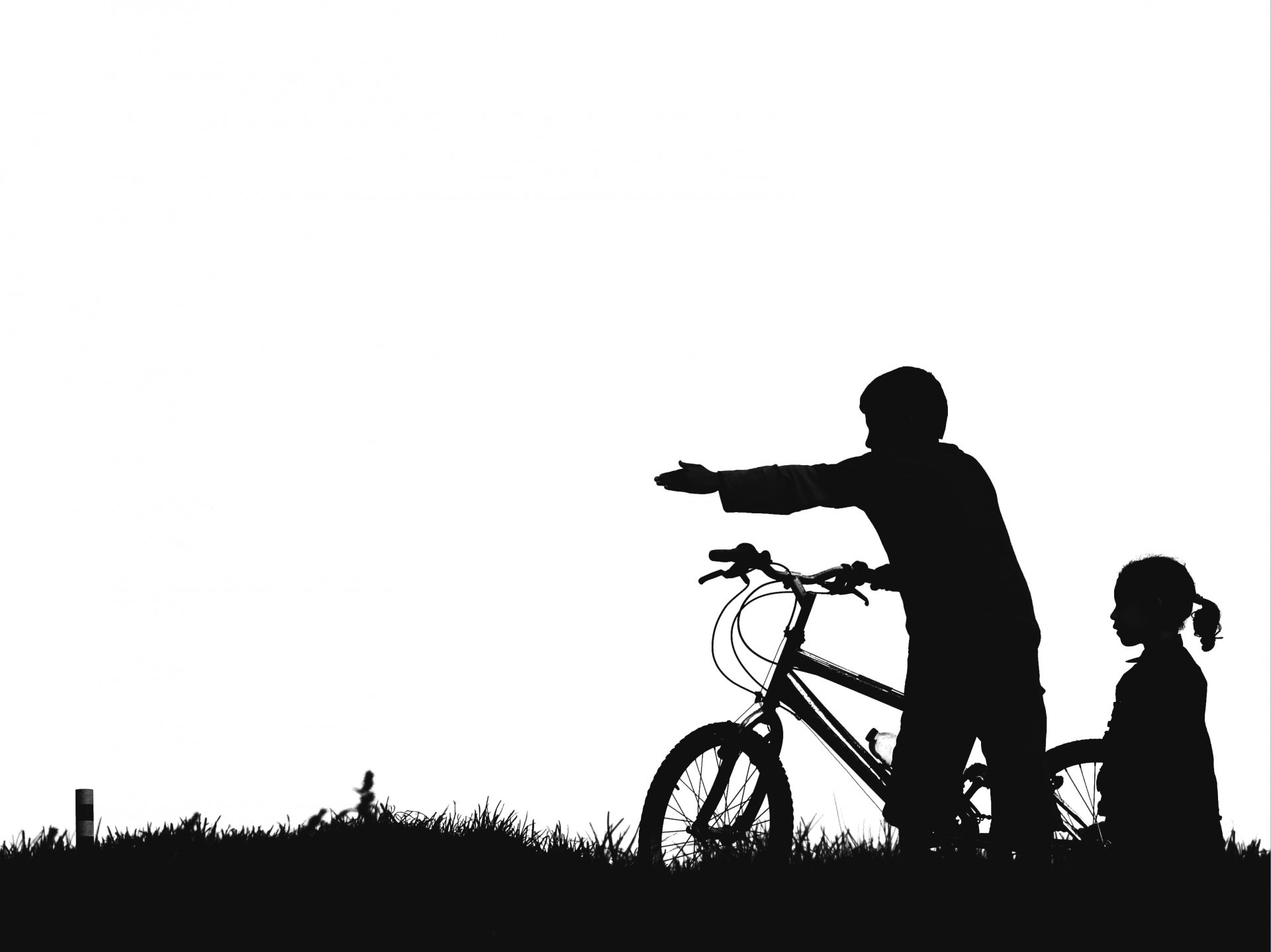 silhouette of boy and girl with bmx bike