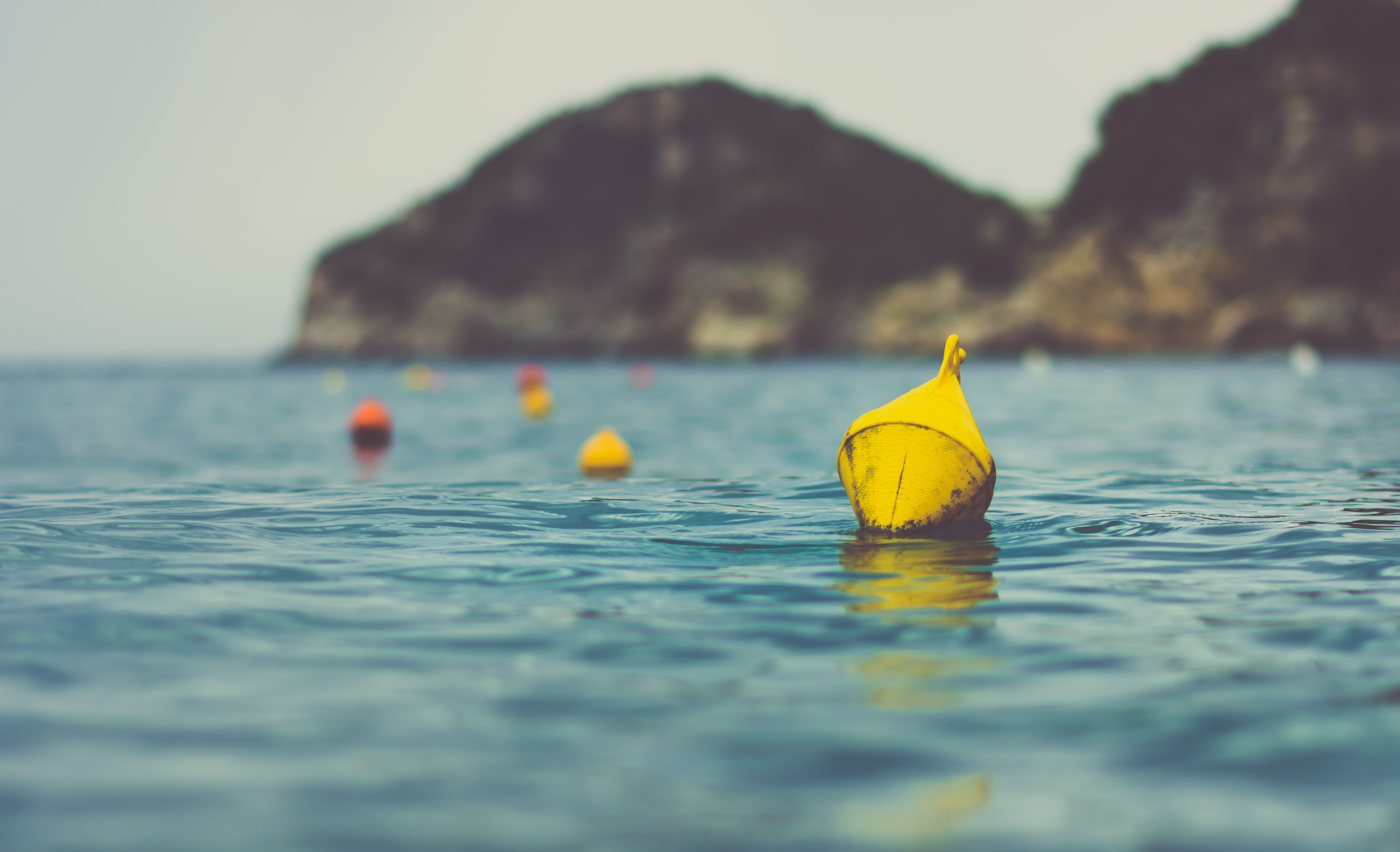 yellow metal bells floating on sea near island