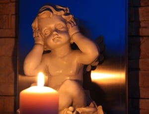 white ceramic cherubim figurine and pillar candle thumbnail
