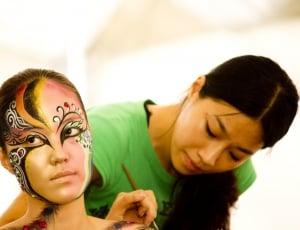 woman in black yellow and green face painting thumbnail