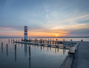 brown wooden dock with white lighthouse thumbnail