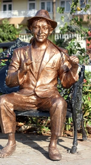 bronze boy sitting on bench statue thumbnail
