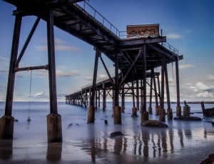 white cumulus clouds over wooden pier during daytime thumbnail