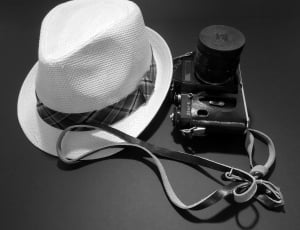 white fedora hat and black dslr camera thumbnail