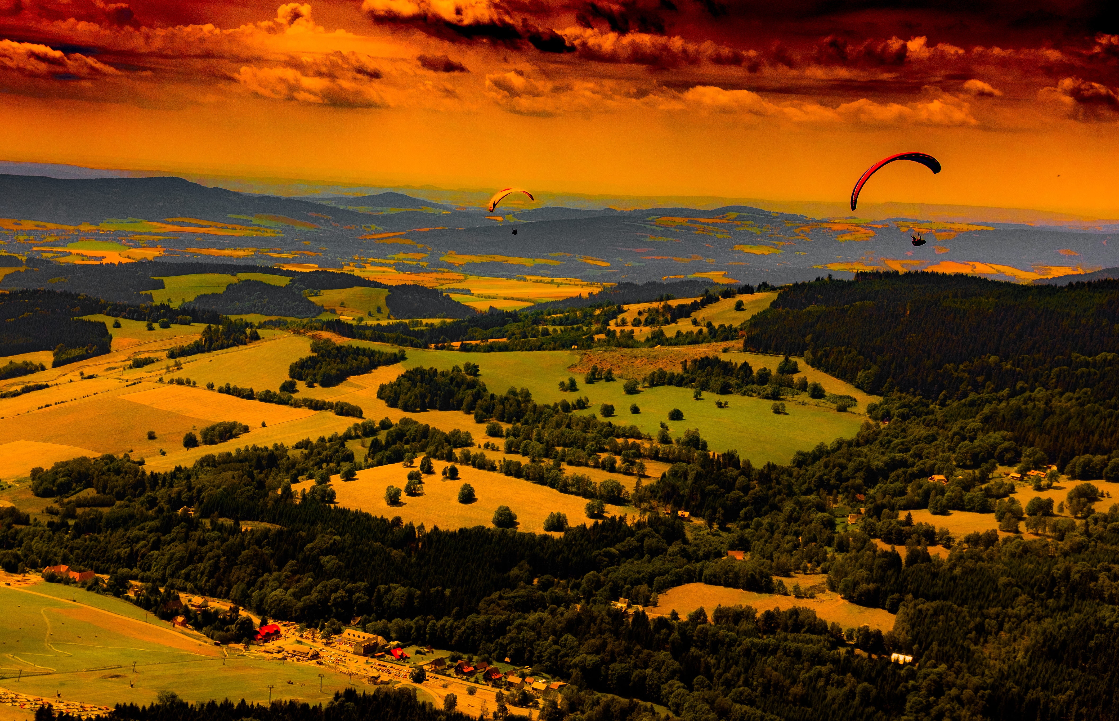 two paragliding in the air in sunset