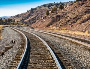 grey metal railroad at daytime thumbnail