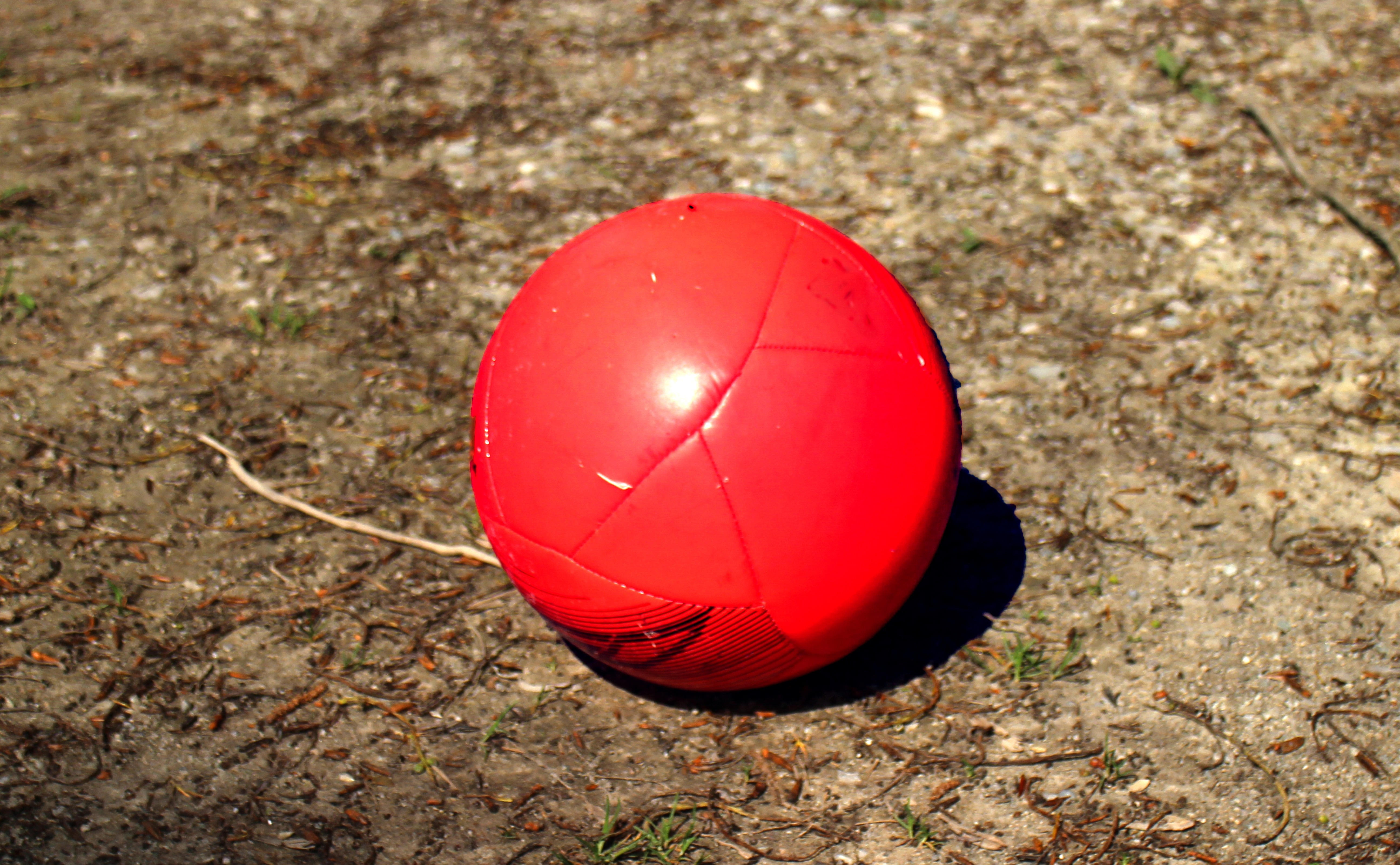 red soccer ball on brown sand
