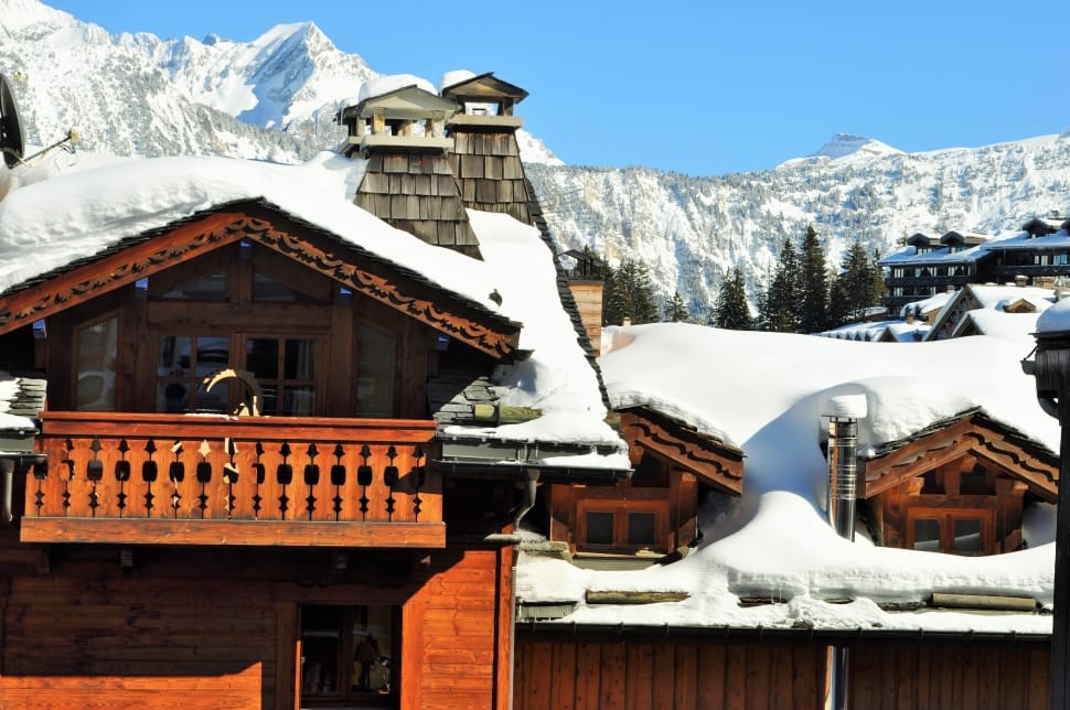 snow capped brown wooden house during daytime preview