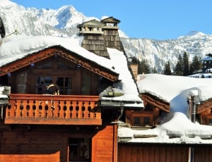snow capped brown wooden house during daytime thumbnail