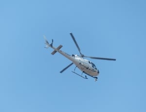 white helicopter flying in the sky thumbnail