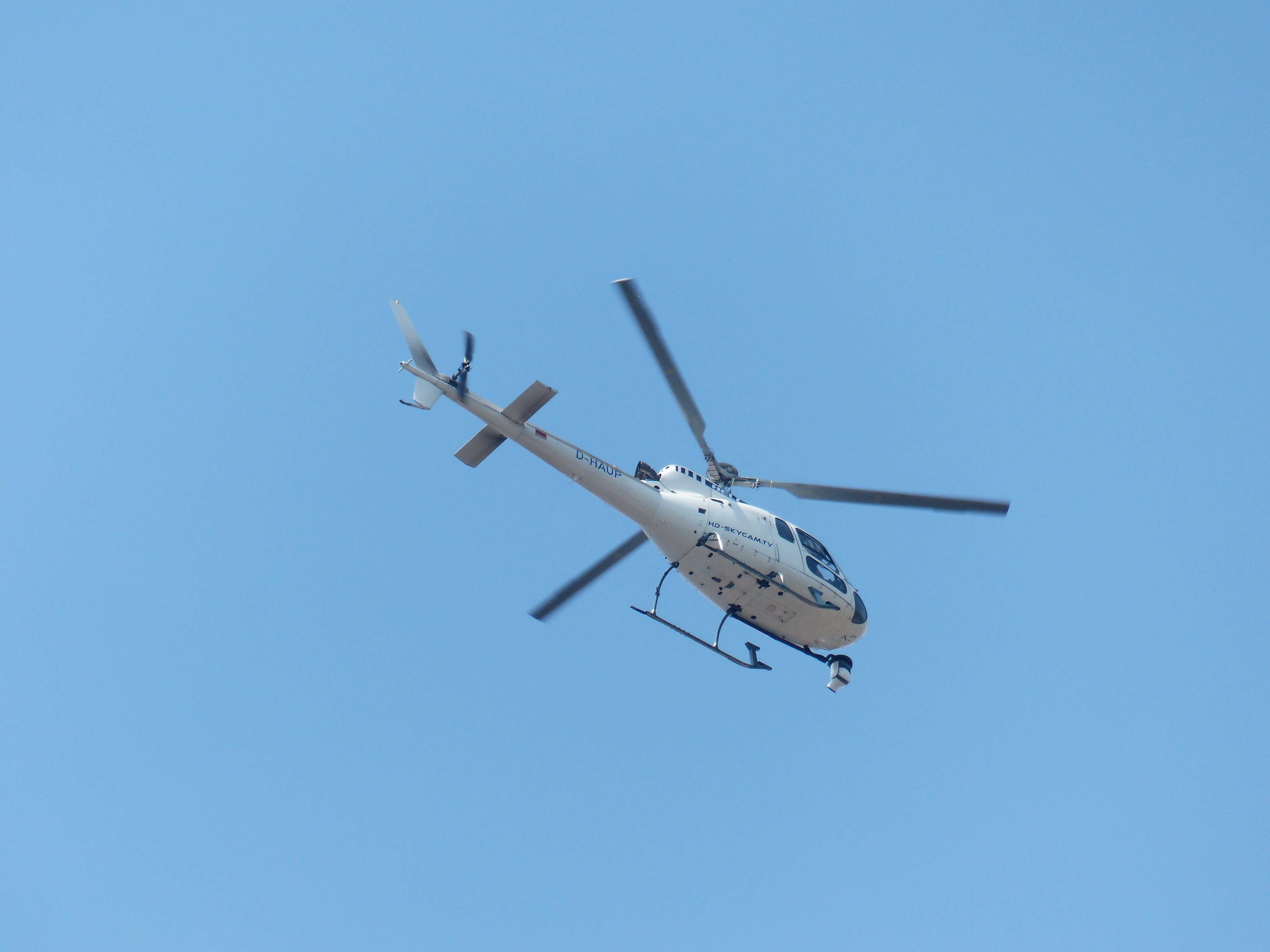 white helicopter flying in the sky