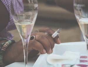 person wearing cigarette near flute glasses thumbnail