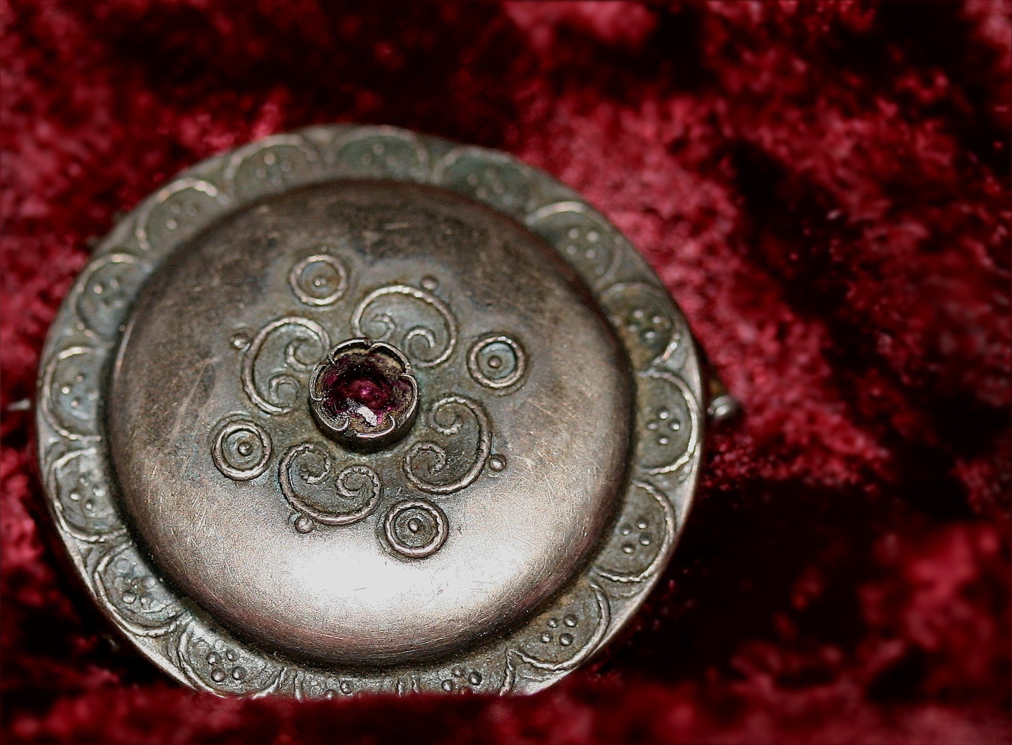round silver covered container on red fleece textile