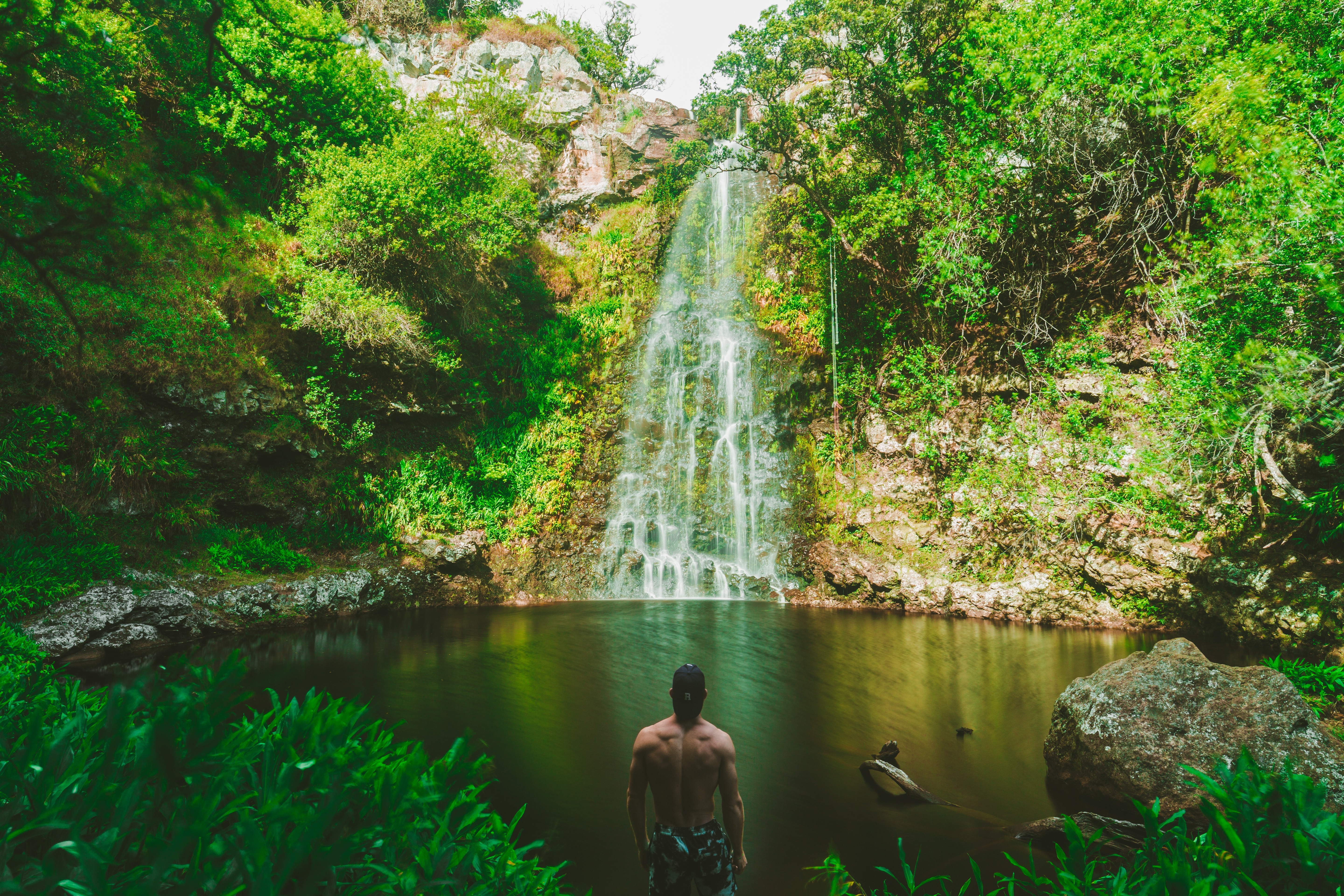 man standing near waterfall during daytime