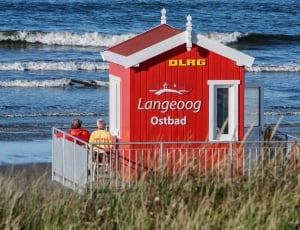 two person standing next to red wall paint DLRG Langeoog Ostbad shed thumbnail