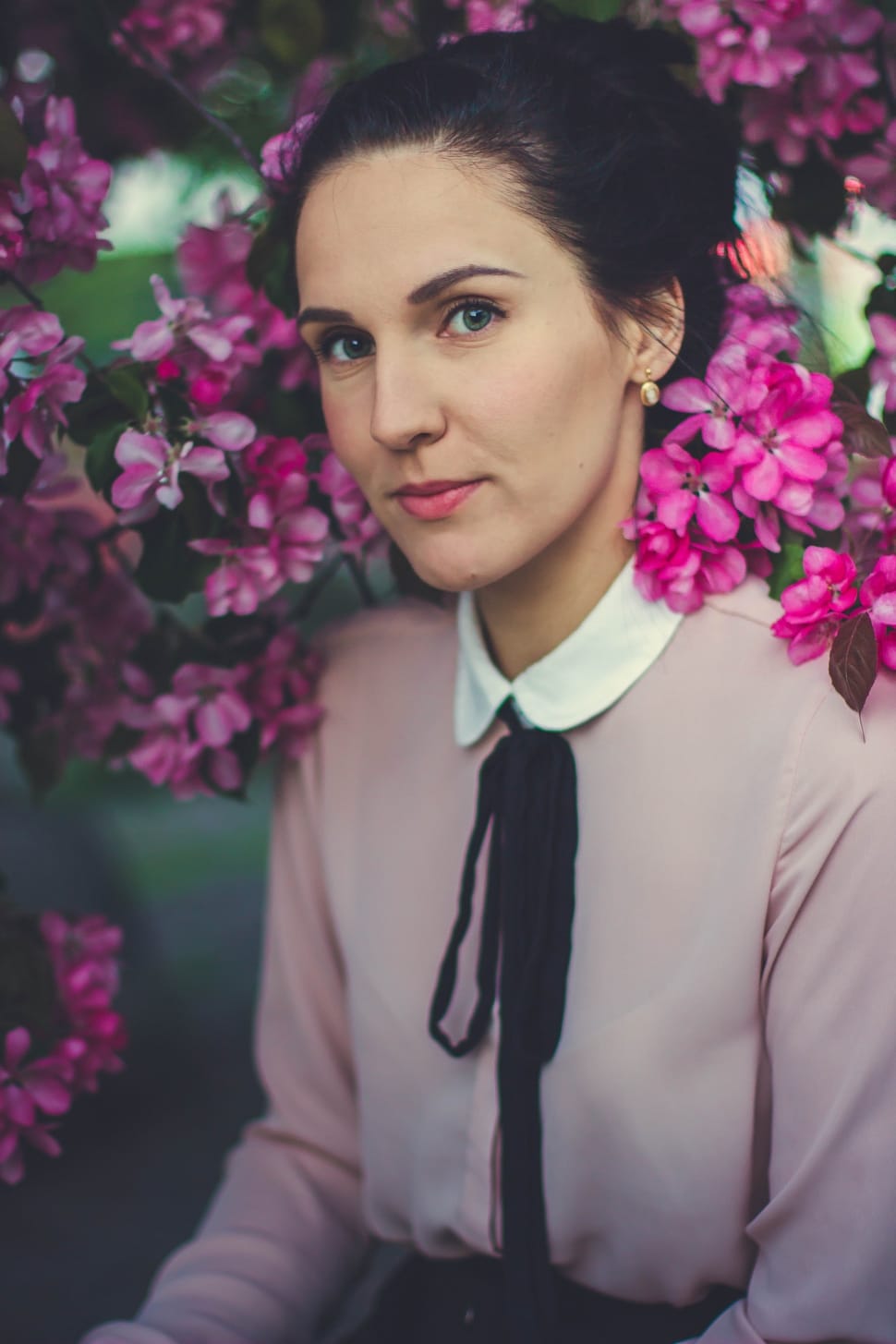 woman in pink and white peter pan collar long sleeved shirt surrounded by pink flowers preview