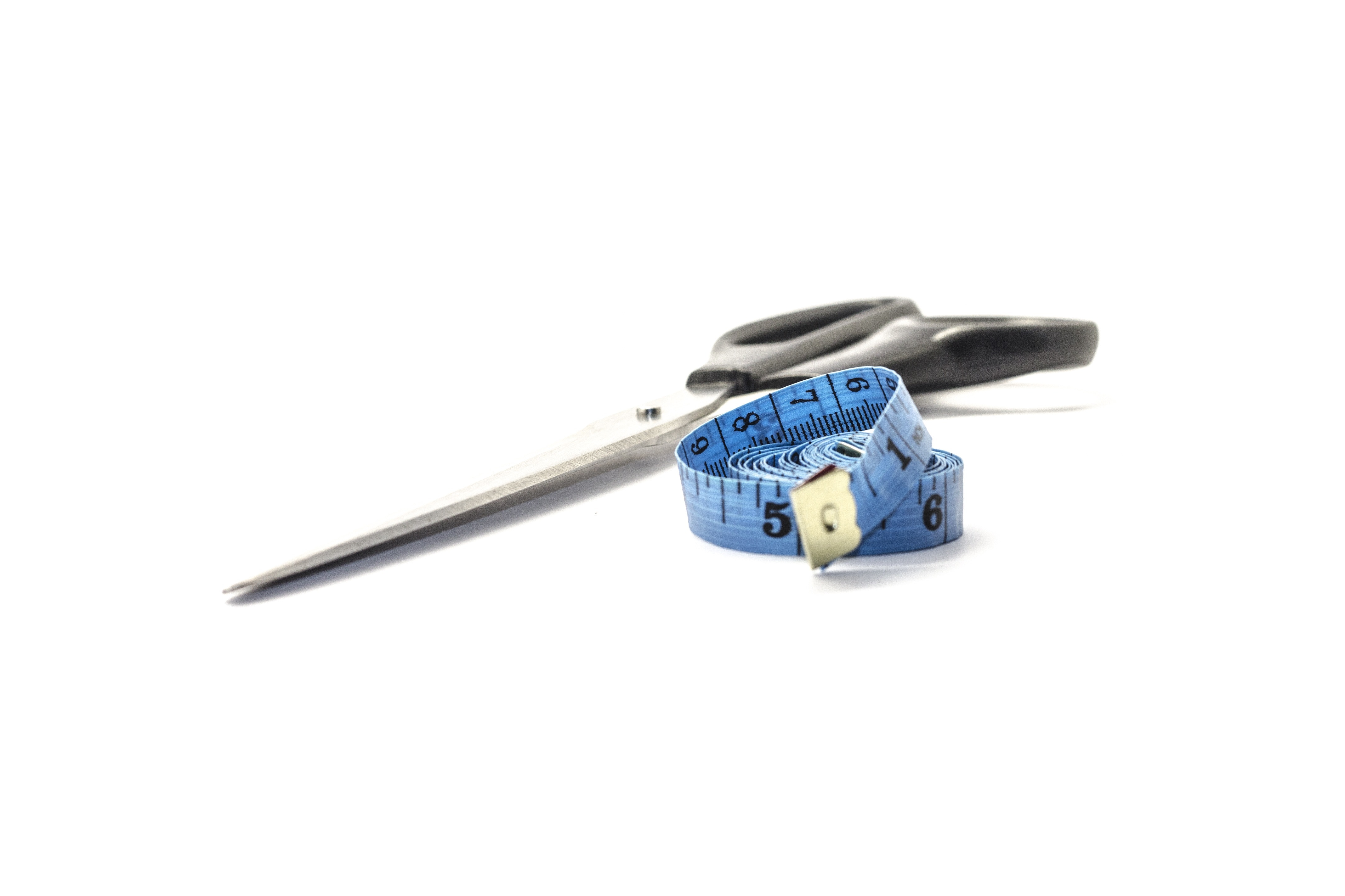 black scissor and blue tape measure