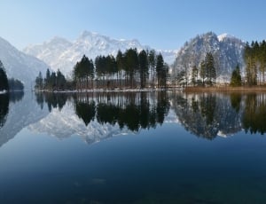reflective photography of trees and lake under blue sky during day time thumbnail
