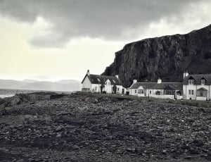 greyscale photo of house beside mountain thumbnail
